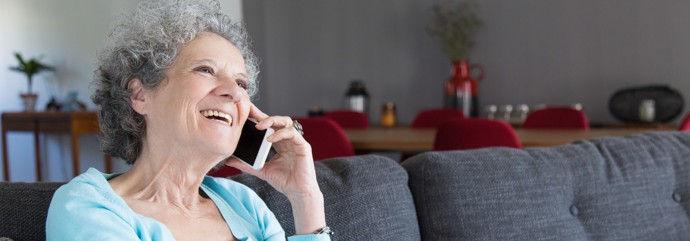 Image of elderly woman smiling on the phone.